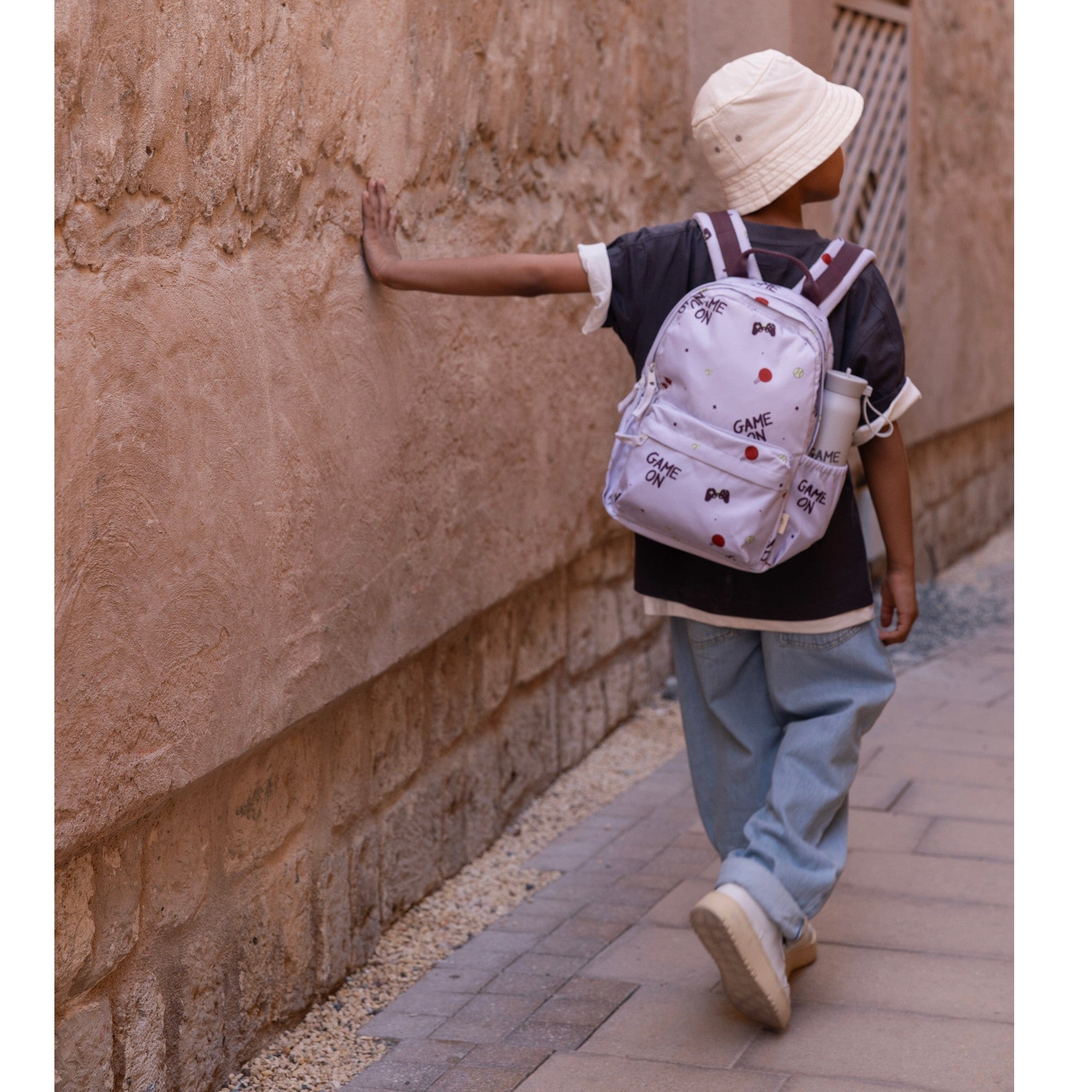 Lil Bunnies - The Collective medium backpack with gaming print worn by a child in a bucket hat and casual clothes