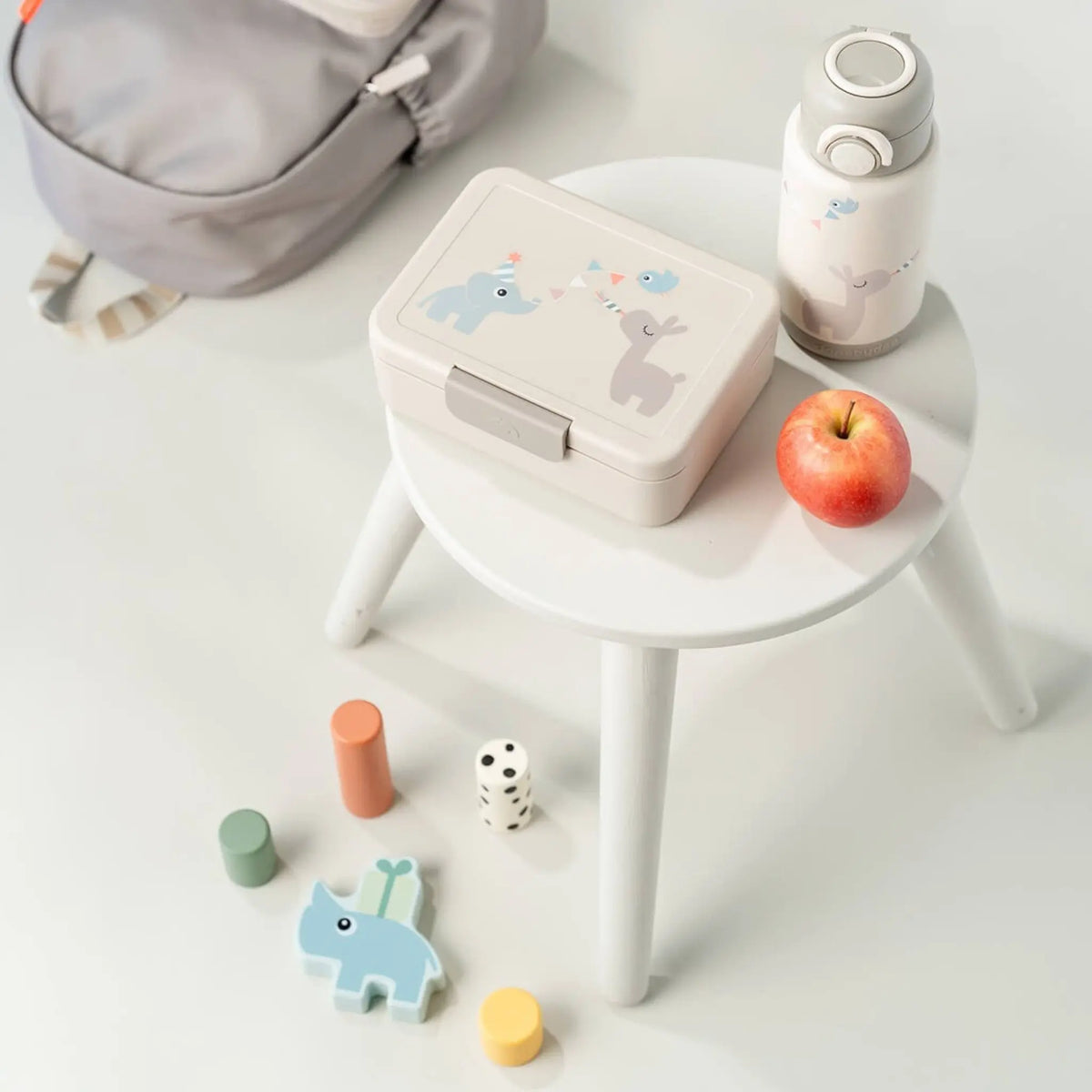 Lil Bunnies - The Collective sand-coloured insulated bottle with cute animal print on a white stool with lunch box