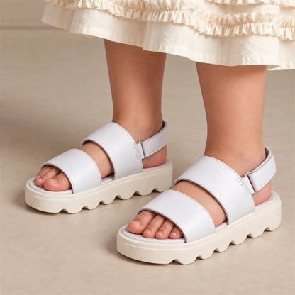 Close-up of girl wearing Babywalker white and off-white sandals with Ivory Sky dress