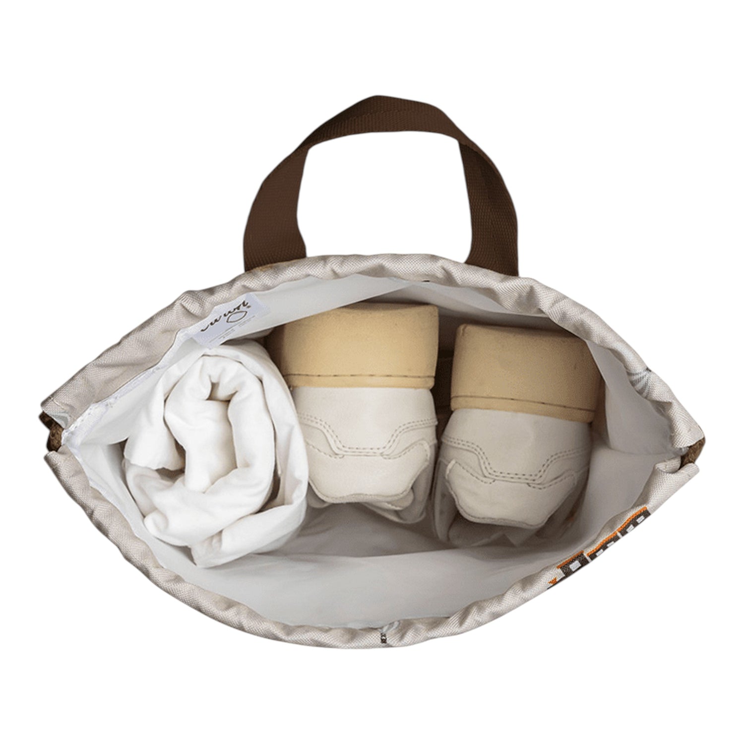 Lil Bunnies - The Collective drawstring wet bag featuring a vehicle print, holding white shoes and a folded cloth.