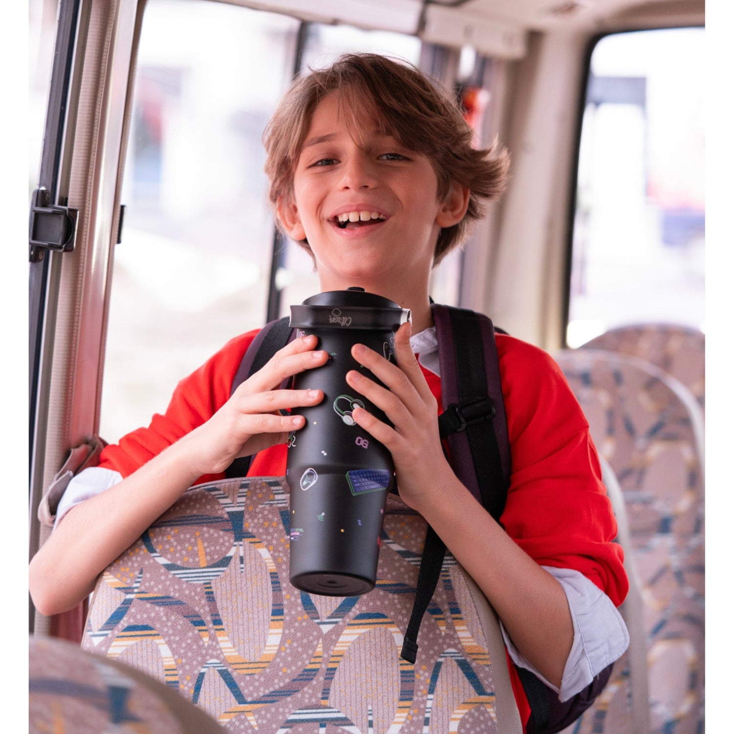 Lil Bunnies - The Collective 900ml black insulated gaming tumbler held by a smiling boy wearing a red sweater