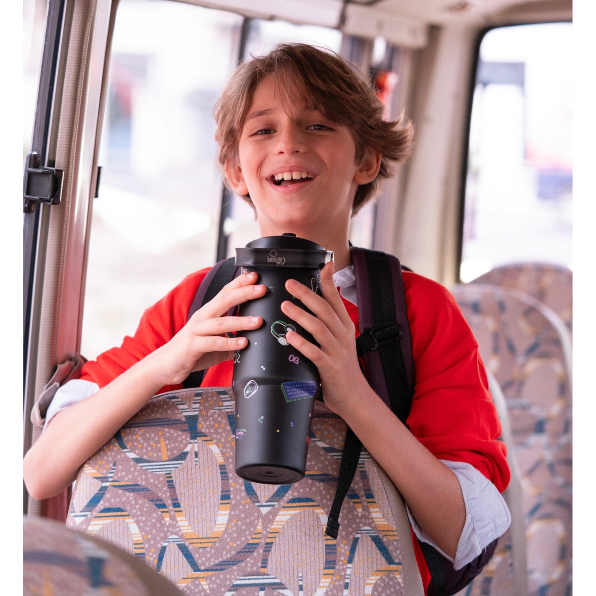 Lil Bunnies - The Collective 900ml black insulated gaming tumbler held by a smiling boy wearing a red sweater