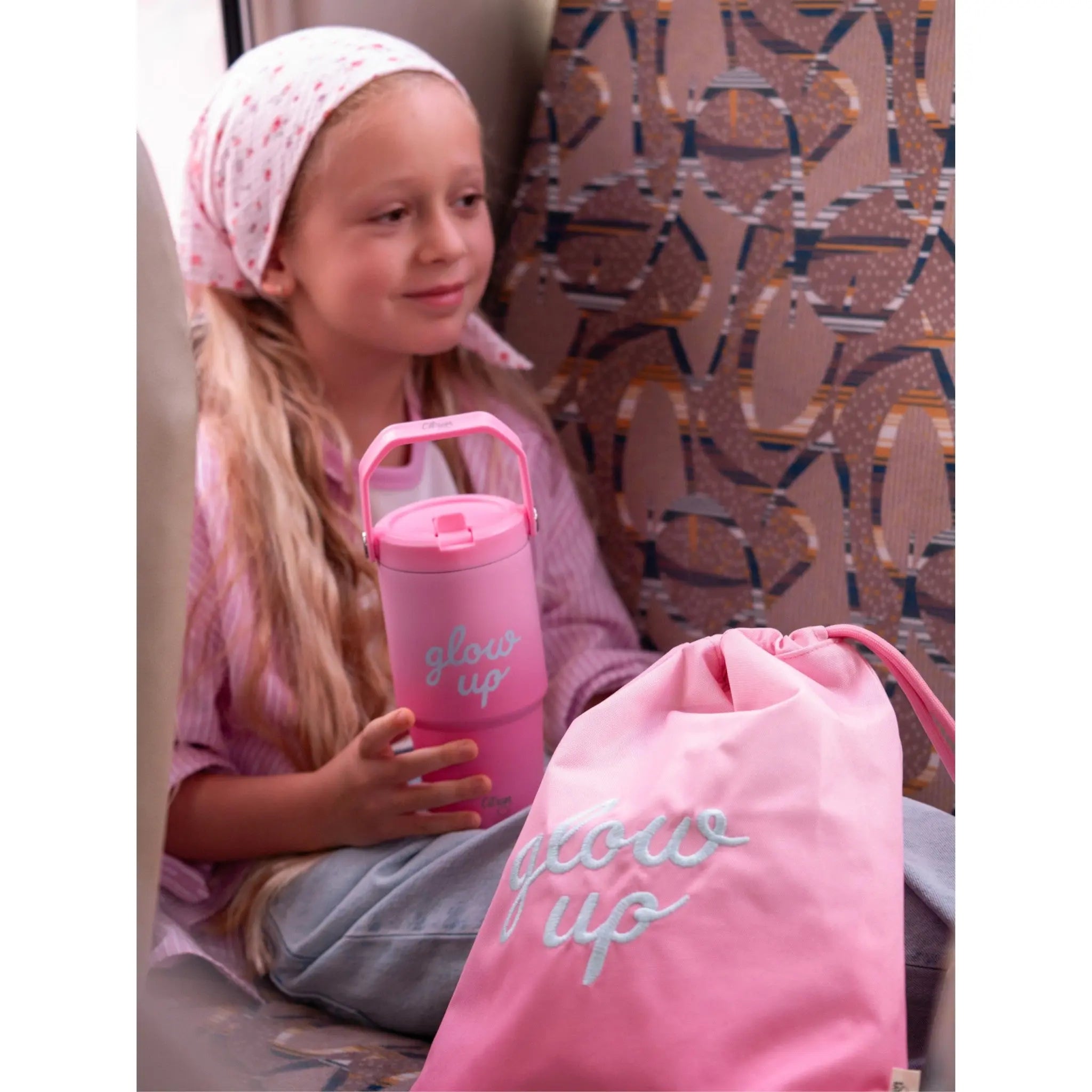 Lil Bunnies - The Collective pink 600ml insulated tumbler with matching drawstring bag held by a young girl