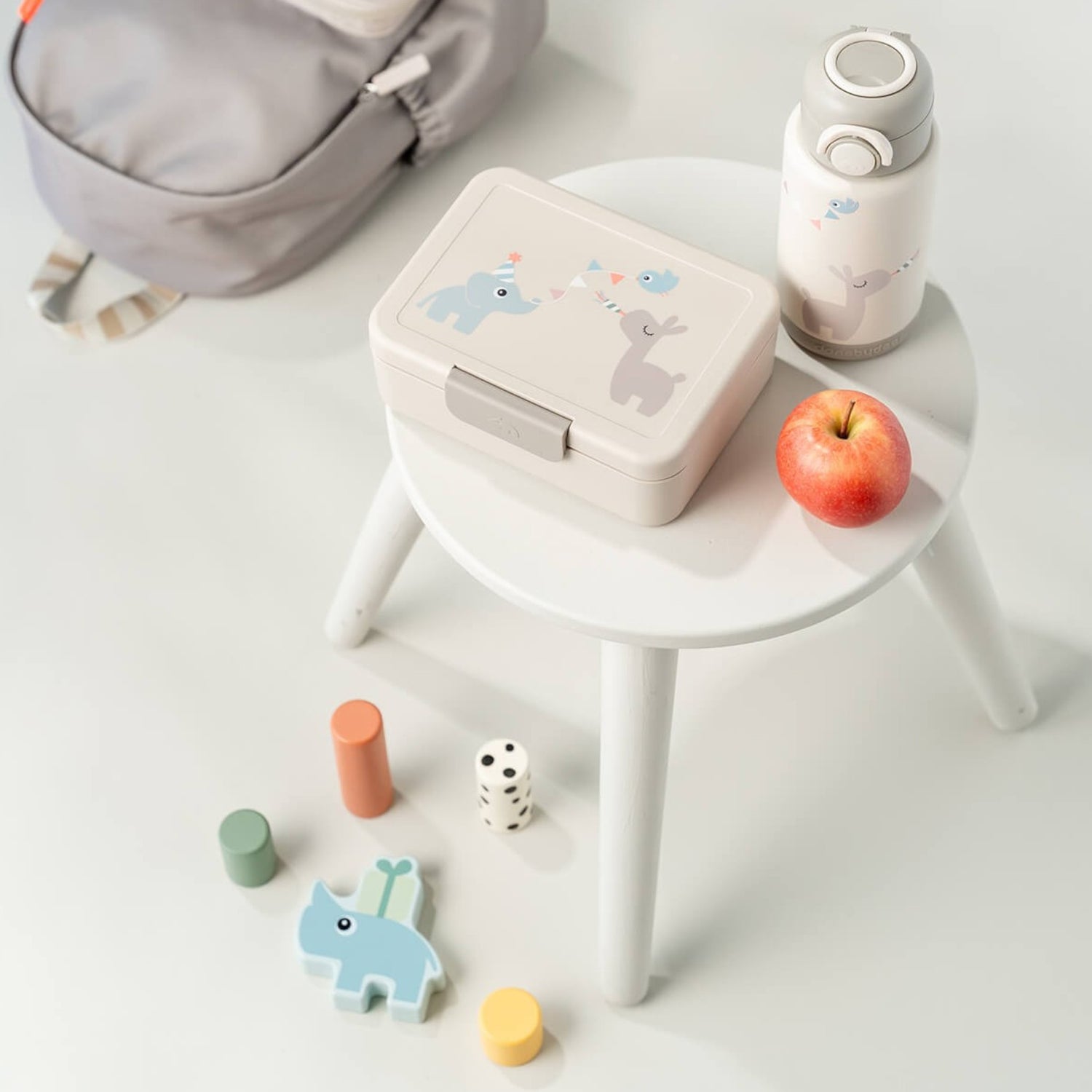 Lil Bunnies - The Collective sand-coloured insulated bottle with cute animal print on a white stool with lunch box