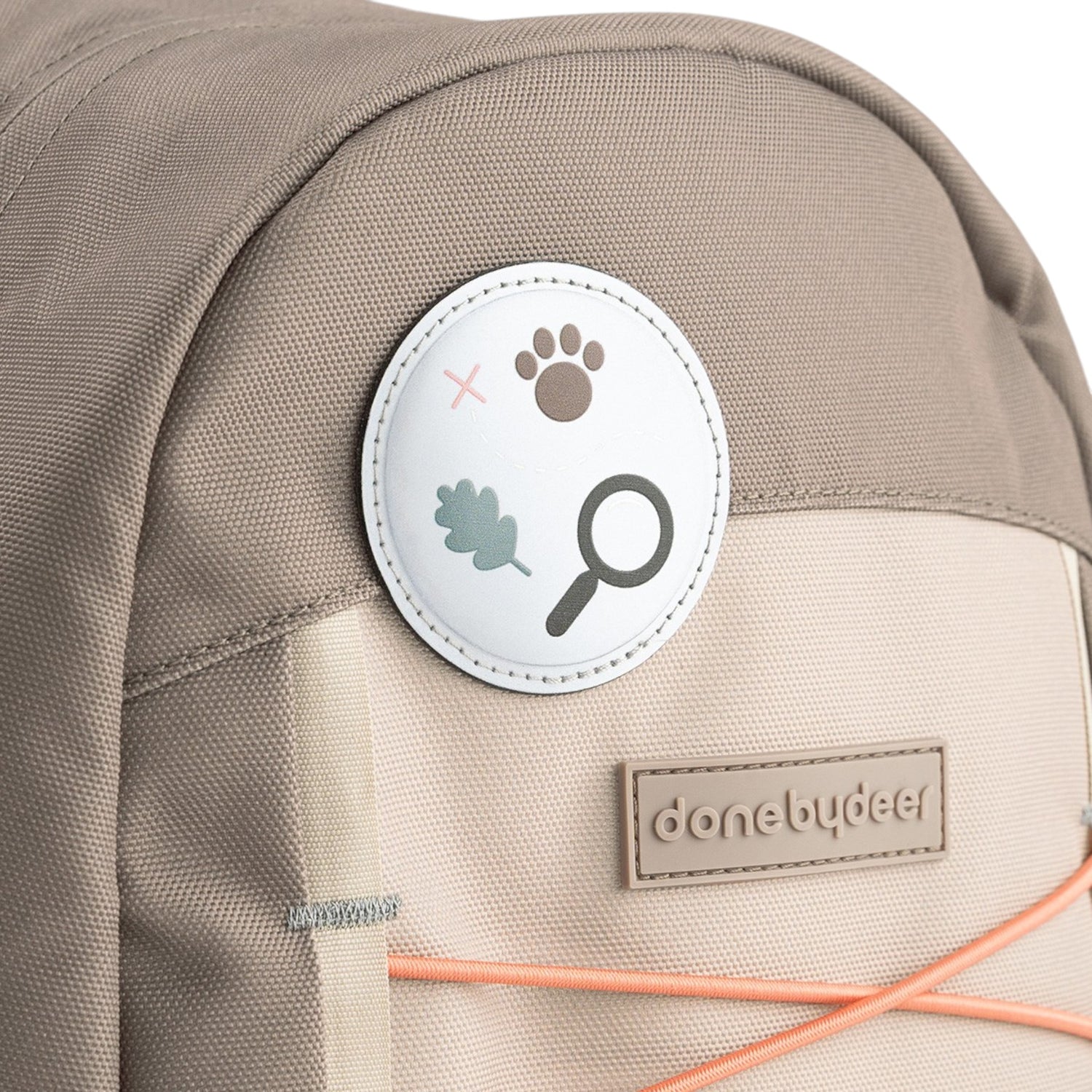 Lil Bunnies - The Collective Junior Backpack in sand featuring a circular nature-themed patch and branded logo tag