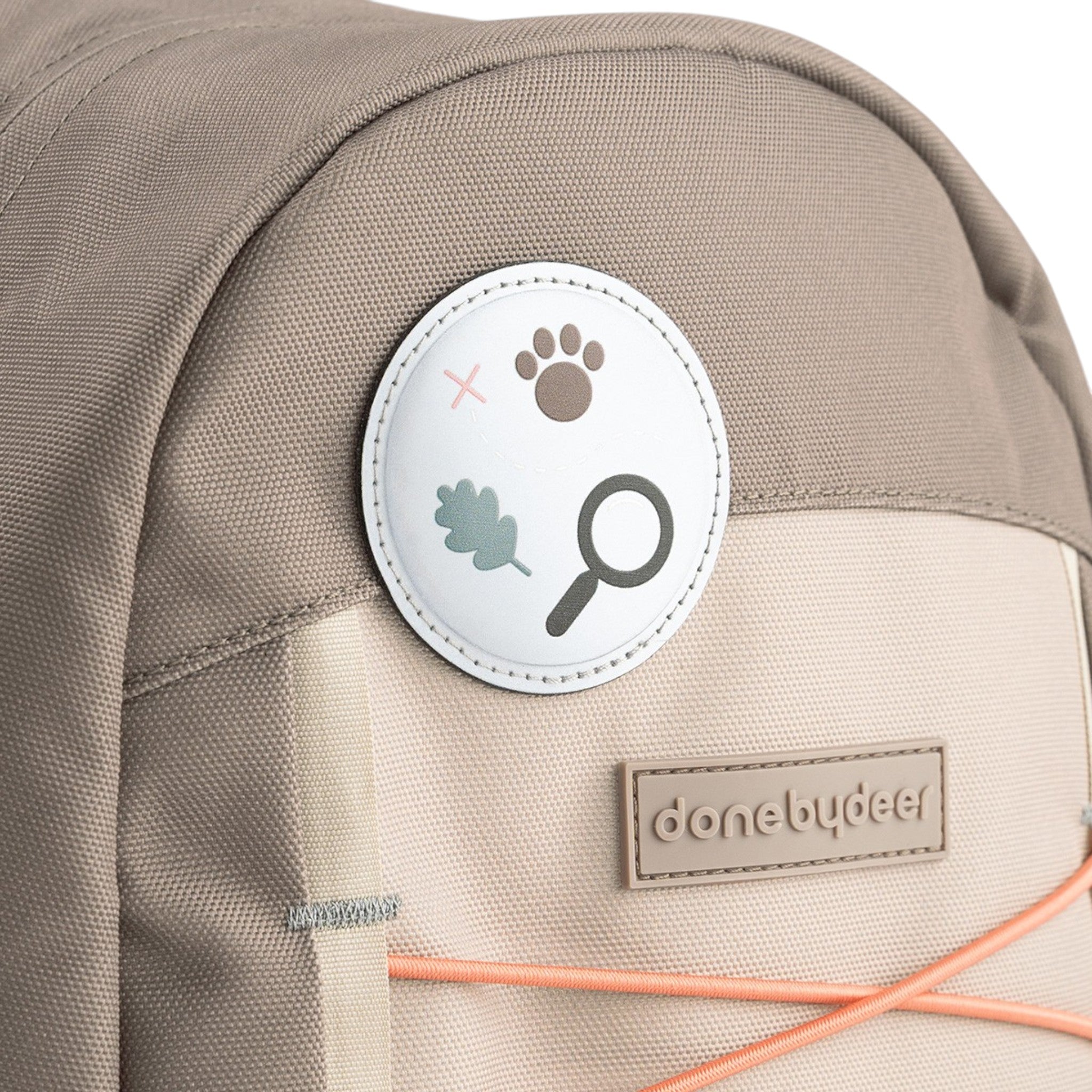 Lil Bunnies - The Collective Junior Backpack in sand featuring a circular nature-themed patch and branded logo tag