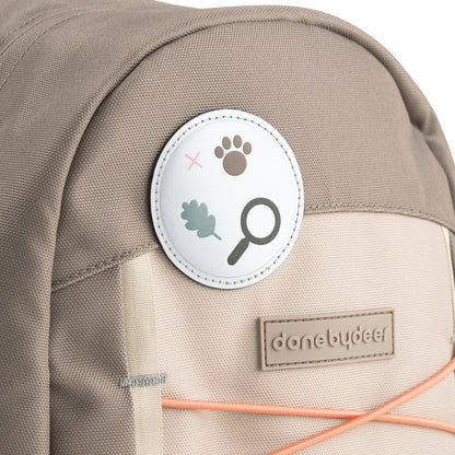 Lil Bunnies - The Collective Junior Backpack in sand featuring a circular nature-themed patch and branded logo tag