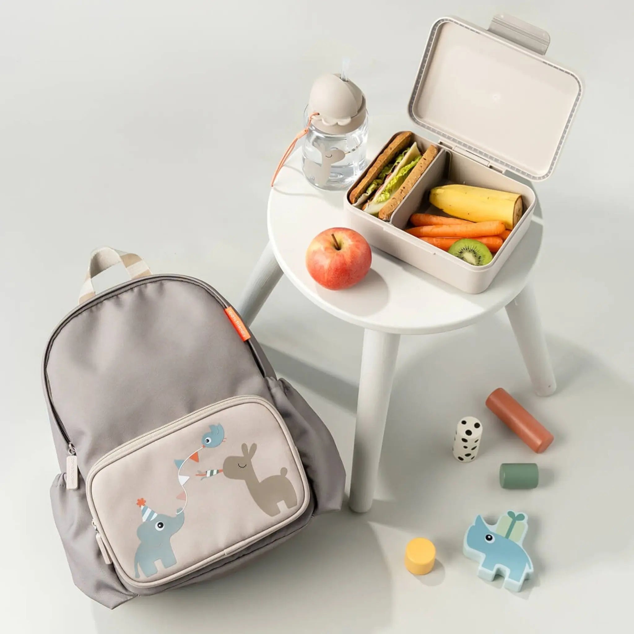 Lil Bunnies - The Collective sand-colored lunch box with divider, open and filled with a sandwich, banana, and kiwi.